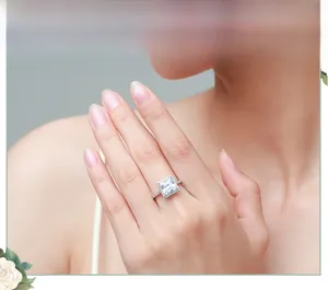Gros plan d'une bague en argent sterling avec diamant coupe princesse sur un doigt