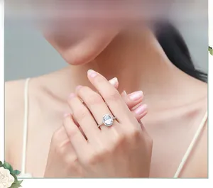 Gros plan d'une bague halo en argent s925 avec pierre ovale portée au doigt