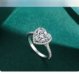Macro shot of s925 silver heart-shaped halo ring with pavé diamonds on green velvet