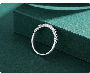 Macro shot of 925 silver eternity ring with prong-set zircon stones on green stand