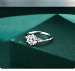 Detail of 1 carat round cut silver ring with six-prong setting on a green stand