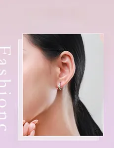 Gros plan d'élégantes créoles en argent sterling s925 avec zircon brillant sur modèle