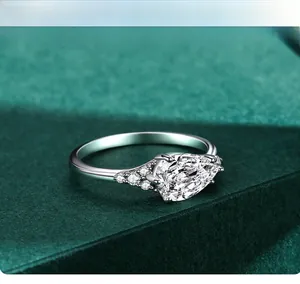 Macro shot of s925 silver pear cut teardrop zircon ring on dark green velvet background