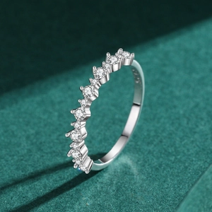 Elegant wavy S925 sterling silver band ring with sparkling stones on green velvet background