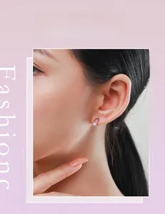 Gros plan d'une boucle d'oreille cœur en argent S925 avec zircon sur l'oreille