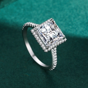 Bague halo carrée en argent avec pavage de diamants sur fond vert foncé mat