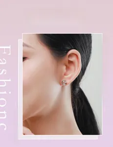 Gros plan de boucles d'oreilles lune en argent S925 avec zircons scintillants sur l'oreille