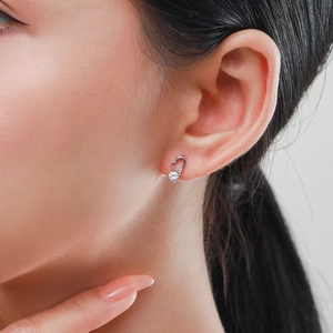 Puce d'oreille cœur évidé en argent S925 avec zircon brillant portée sur le lobe d'oreille