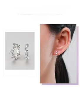 Detail of S925 silver wave earrings with marquise zirconia crystals on a model