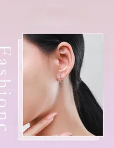 Gros plan de boucles d'oreilles créoles en argent S925 avec cristaux pavés sur modèle