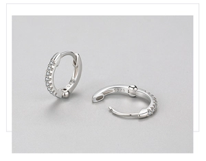Dettaglio degli orecchini huggie in argento S925 con zirconi e marchio inciso