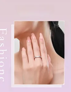 Gros plan d'une bague en argent s925 sertie de quatre petits diamants sur un doigt