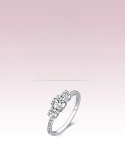 Macro detail of three-stone s925 silver ring with clear cubic zirconia in pink background