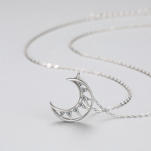 S925 sterling silver crescent moon pendant necklace with cubic zirconia on a grey background