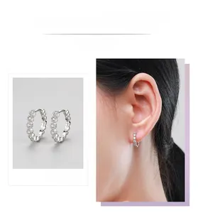 Détail de créoles en argent 925 avec zircons blancs et vue portée par un mannequin