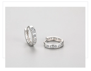 Macro shot of silver S925 huggie earrings with pave-set square and round white zircons
