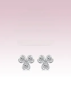Detail of S925 silver clover earrings with round zirconia stones on a pink background