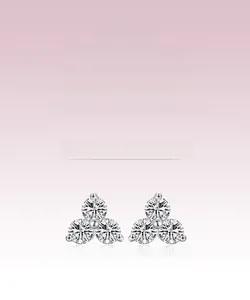Macro shot of silver stud earrings featuring three round-cut sparkling cubic zirconia stones