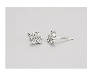 Macro shot of silver clover stud earrings featuring sparkling cubic zirconia stones