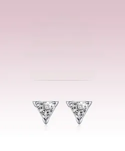 Macro detail of triangle silver stud earrings featuring sparkling cubic zirconia stones