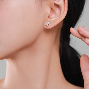 Elegant s925 silver bow stud earrings with sparkling cubic zirconia worn by a model