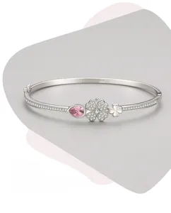 Detail of silver clover bangle featuring pink pear-cut stone and polished finish
