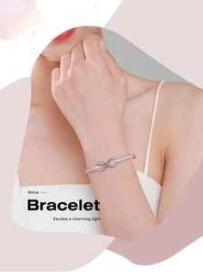 Détail d'un bracelet infini en argent s925 orné de zircons brillants sur un poignet femme