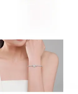 Close-up of S925 silver four-leaf clover bracelet with pink teardrop gemstone
