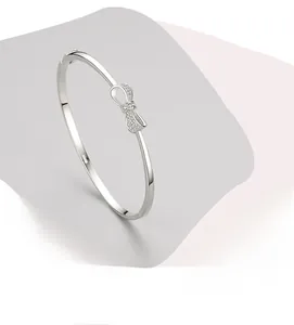 Gros plan montrant le sertissage manuel de zircons sur le bracelet nœud en argent