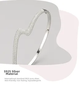 Detailed view of S925 sterling silver bangle with wavy design and pavé cubic zirconia