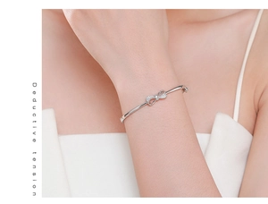 Gros plan d'un bracelet nœud en argent s925 avec zircons micro-pavés sur un poignet