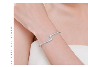 Macro detail of wave S-shaped silver bangle with micro-pave cubic zirconia stones