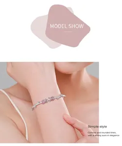 Macro shot of s925 silver rose bracelet with pink pavé crystals on a model's wrist