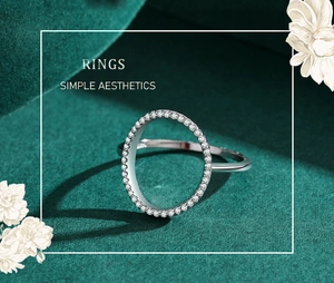 Détail macro d'une bague ovale en argent avec pavé de zircons sur velours vert