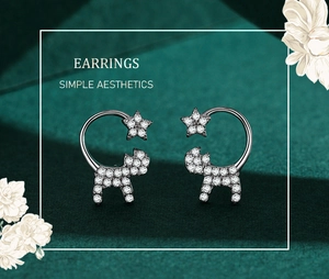 Close-up of S925 silver cat earrings with sparkling cubic zirconia on green velvet