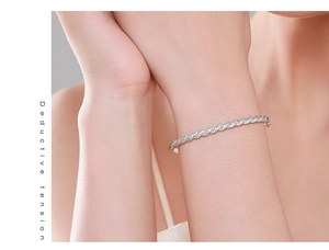 Gros plan du bracelet torsadé en argent avec zircons blancs micro-pavés sur le poignet