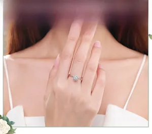 Primo piano di un anello in argento s925 con grappolo floreale scintillante sulla mano di un modello