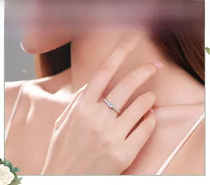 Primo piano di un anello in argento S925 con diamante a quattro griffe indossato da modella