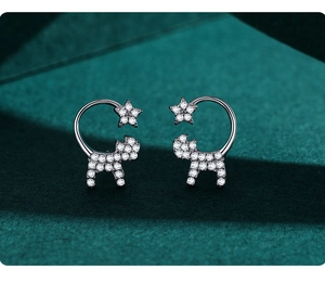 Macro detail of S925 silver cat and star stud earrings with shimmering zircons