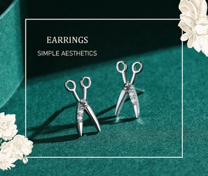 Detailed view of silver scissor-shaped earrings with sparkling cubic zirconia accents