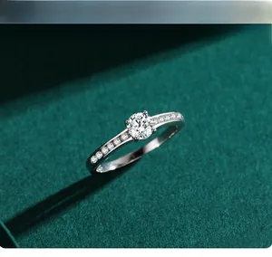 Dettaglio macro di un anello solitario a sei griffe con diamanti laterali su velluto verde