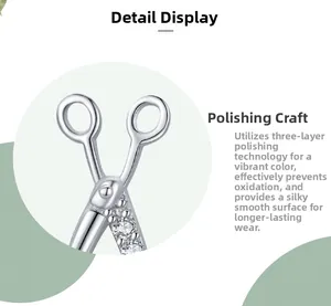 Macro detail of silver scissor stud earrings showing zircon inlay and polished texture