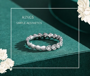 Close-up of heart-shaped S925 silver ring with pave-set crystals on a green background