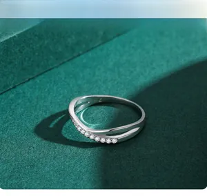 Macro shot of 925 sterling silver criss-cross ring with white zircon stones on green stand