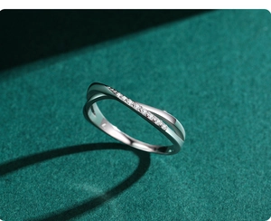 Macro shot of silver criss-cross ring with micro-paved cubic zirconia on dark background