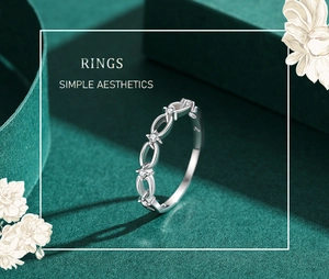 Detailed view of silver S925 chain link ring with star-set diamonds on green fabric