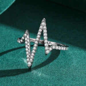 Minimalist S925 sterling silver heartbeat ring with zircon stones on green velvet