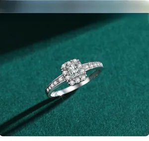 Macro view of emerald cut silver ring with halo and side diamonds on velvet
