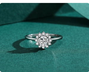 Macro detail of silver sunflower ring with brilliant center stone on green background