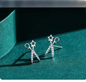 Macro view of S925 silver scissor stud earrings with star cutout and zircon pavé